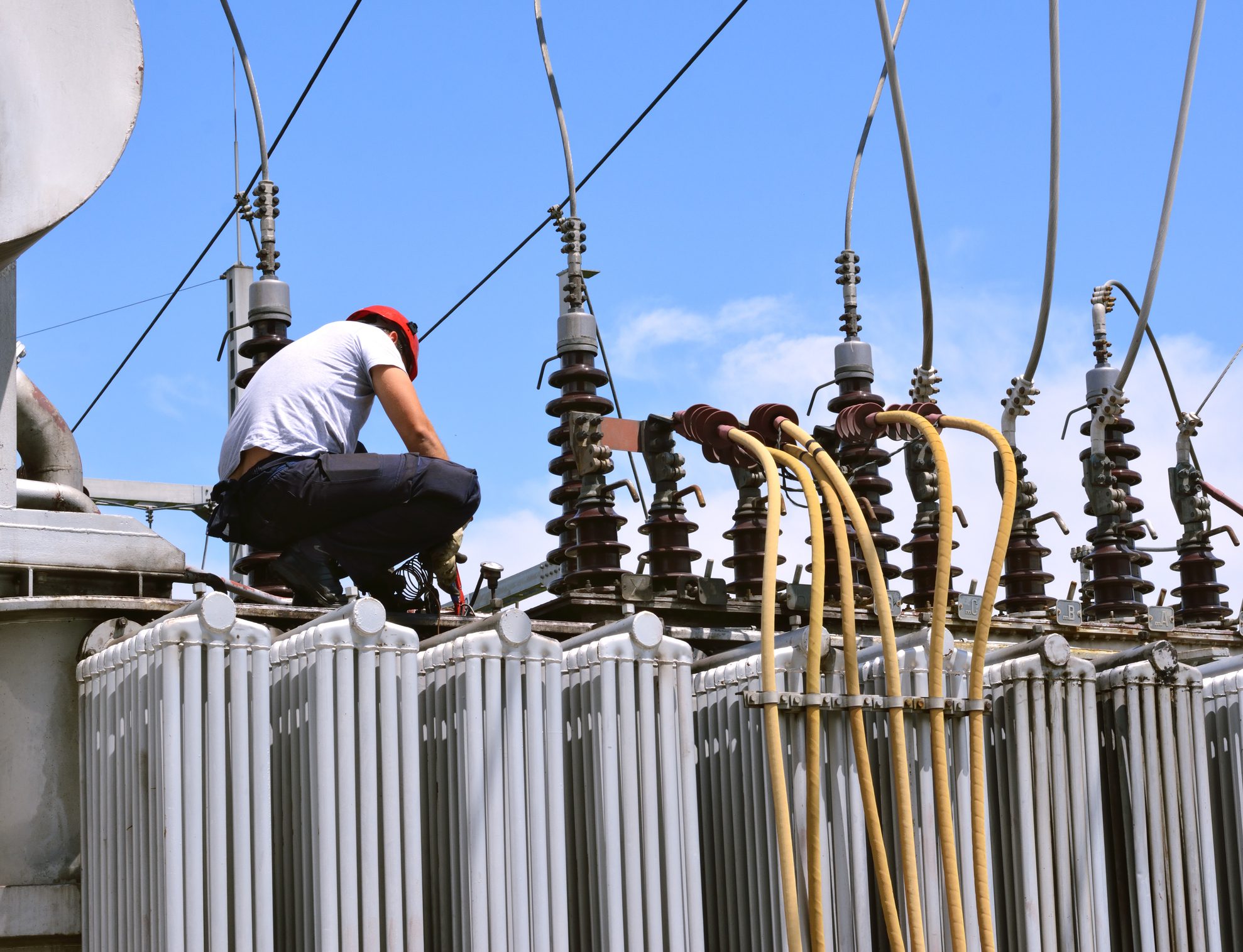 Technician working on electrical transformer equipment.